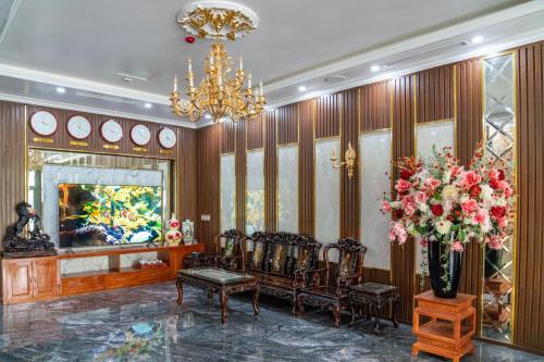 a lobby with chairs and a chandelier and flowers at Hương Nam Hotel in Ha Long