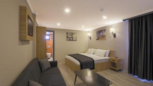 Habitación de hotel con cama y sofá en Side Leon Otel, en Side