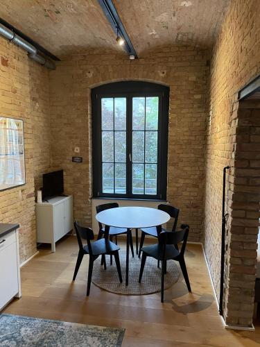 a table and chairs in a room with a brick wall at Stylisches Loft mitten in Berlin in Berlin