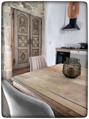 - une cuisine avec une table en bois et un panier dans l'établissement ÔRacines du Calme Maison Hortense, à Sanilhac