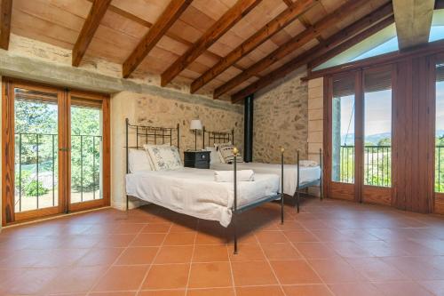 een slaapkamer met een bed in een kamer met ramen bij Sa Teulera in Sencelles
