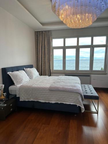 a bedroom with a large bed and a chandelier at Villa Isabella - Luxury with style right next to the beach, private pool and sea view in Opatija