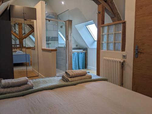 1 dormitorio con 1 cama con toallas en La Grange de la Porterie - Magnificent House and Barn Conversion in Historic village, en Chapaize