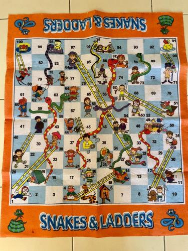 a board game with snakes and ladders on it at Zarahome in Tambun