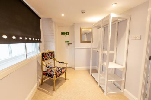 a room with a chair and a window and a television at The Old Vicarage Hotel & Restaurant in Bridgwater