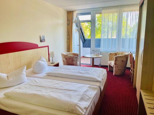 a hotel room with two beds and a window at Morada Hotel Am Mellensee in Klausdorf Brandenburg