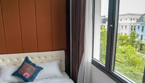 a bed in front of a window with a pillow at Hương Nam Hotel in Ha Long