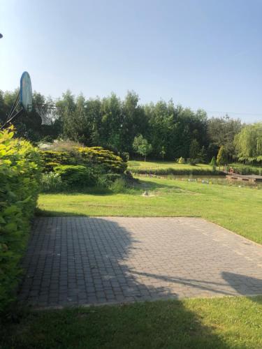 a brick walkway in a park with a grass field at Stacja Wygoda in Lubiszewo