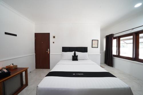 a bedroom with a large white bed and a window at DS Colive Marina in Semarang