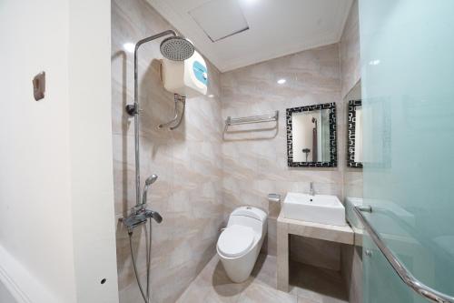 ein Bad mit einem WC, einem Waschbecken und einer Dusche in der Unterkunft DS Colive Marina in Semarang