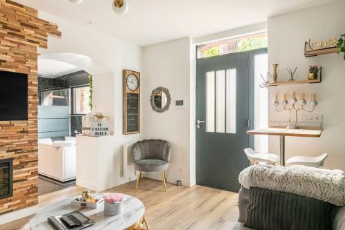 a living room with a couch and a fireplace at Sauna, jacuzzi, terrasse et parking in Rouen