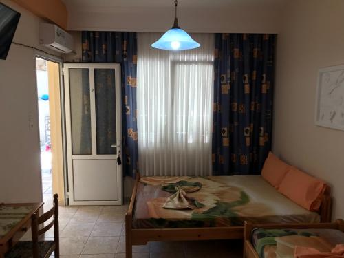 a bedroom with a bed and a door with a window at Oregon in Paralia Katerinis