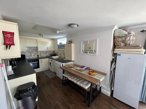 a small kitchen with a table and a refrigerator at The Garden Flat in Paignton