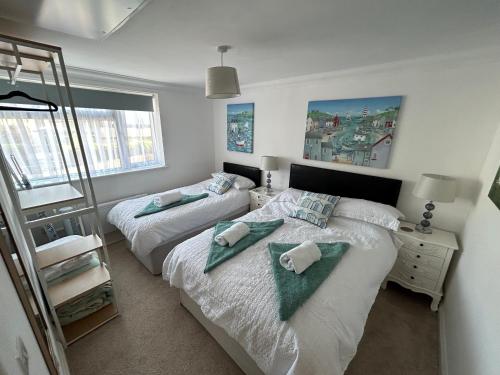a bedroom with two beds with towels on them at The Garden Flat in Paignton