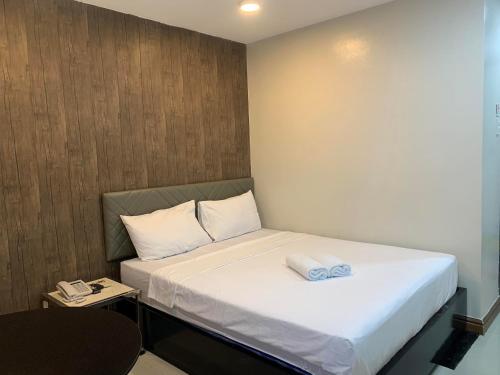 a small bedroom with a bed with white sheets at Maine City Residences in Manila