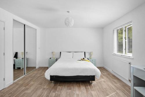 - une chambre blanche avec un lit et un miroir dans l'établissement The Clover Lodge, Red Lake Farm Nr Glastonbury, à Somerton