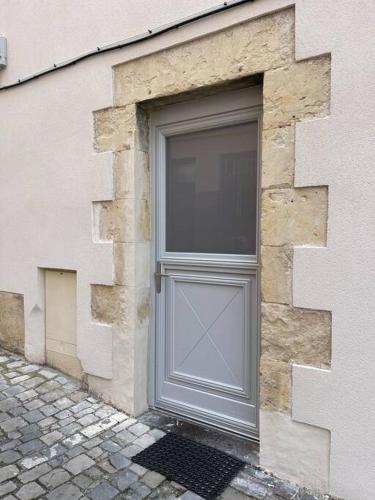 une grande porte grise sur le côté du bâtiment dans l'établissement Le cocon des ducs, appartement centre historique, à Nevers