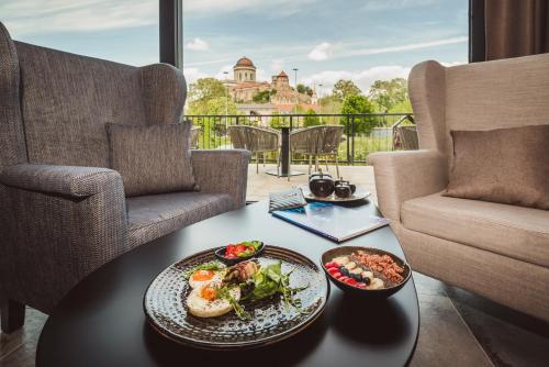 una mesa con un plato de comida en el balcón en Mediterraneo Luxury Room Esztergom, en Esztergom