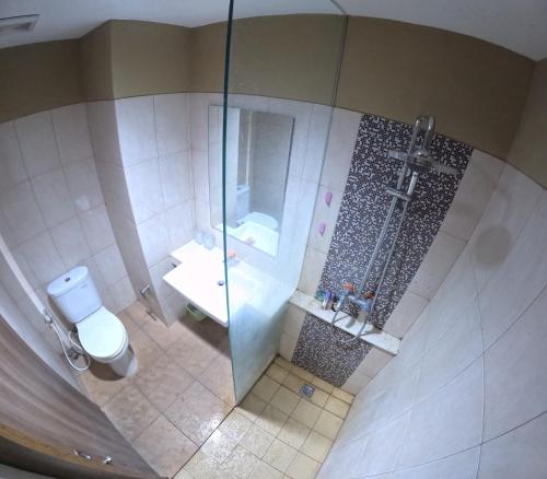 - une vue de tête sur la salle de bains pourvue d'une douche et de toilettes dans l'établissement Student Park 740 by We Stay, à Seturan