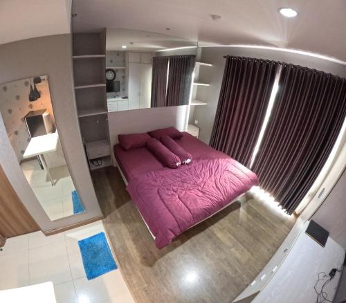 - une chambre avec un lit violet et un grand miroir dans l'établissement Student Park 740 by We Stay, à Seturan