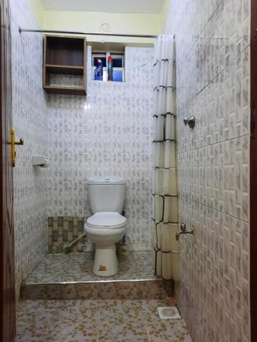 ein Bad mit einem weißen WC in einem Zimmer in der Unterkunft La Casa Nakuru in Nakuru