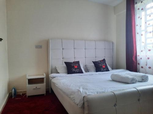 ein Schlafzimmer mit einem weißen Bett mit zwei Kissen darauf in der Unterkunft La Casa Nakuru in Nakuru