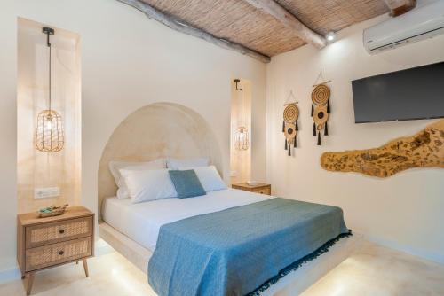 a bedroom with a bed and a tv on the wall at Disegno Villa - Rooftop Pool in Kolymvari