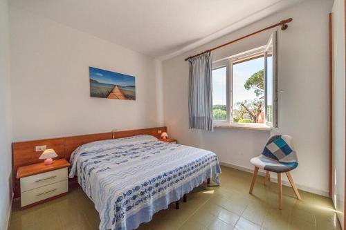 - une chambre avec un lit, une chaise et une fenêtre dans l'établissement Villa Cecilia - Appartamenti, à Procchio