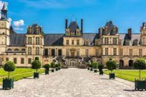 a large building with a courtyard in front of it at MAISON & JARDIN PRIVÉ CENTRE VILLE in Fontainebleau