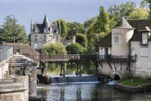 a bridge over a river in front of a house at MAISON & JARDIN PRIVÉ CENTRE VILLE in Fontainebleau