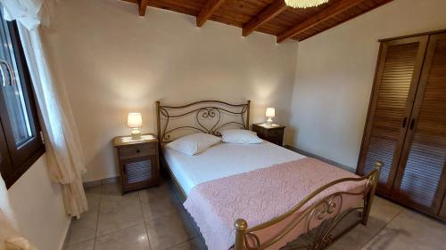 1 dormitorio con 1 cama con 2 mesitas de noche y 2 lámparas en Nature Villa, en Volímai
