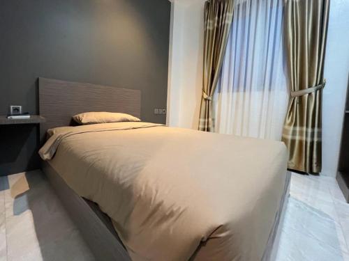a bedroom with a large bed and a window at PURNAMA BALIGE HOTEL in Balige