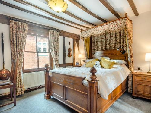 a bedroom with a wooden bed with a canopy at Northgate Bakery Annex in Beccles