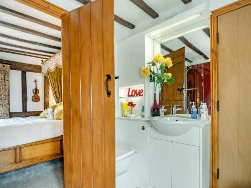 a bathroom with a sink and a bed with a mirror at Northgate Bakery Annex in Beccles