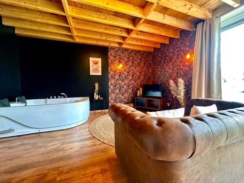 uma sala de estar com uma banheira e um sofá em Hour House - Esc'Appart em Houyet