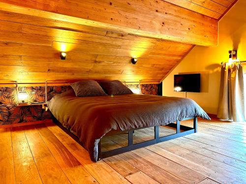 Cama en habitación con techo de madera en Hour House - Esc'Appart, en Houyet