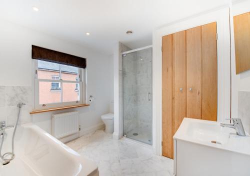 uma casa de banho com uma banheira, um lavatório e um chuveiro em Zeppelin em Woodbridge