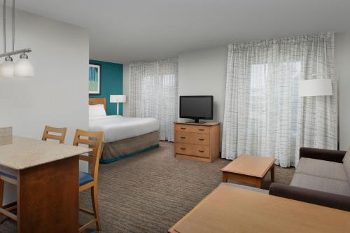 Habitación de hotel con cama y TV en Residence Inn Chico, en Chico