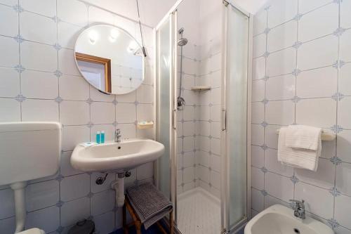 a bathroom with a sink and a toilet and a mirror at Villa Cecilia - Appartamenti in Procchio