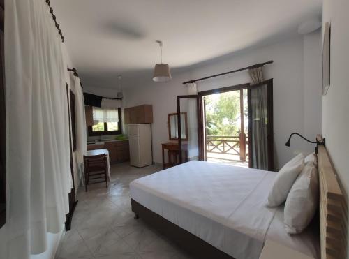 una camera con un grande letto bianco e una cucina di Para Thin Alos Inn a Néos Marmarás