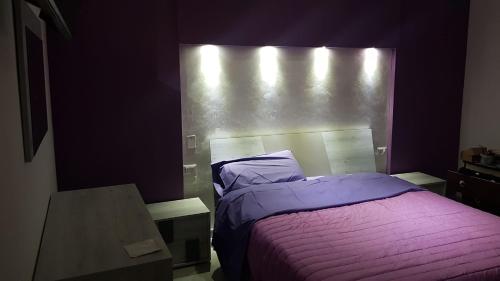 - une chambre avec un lit et une couverture violette dans l'établissement CASA DAVID, à Manfredonia