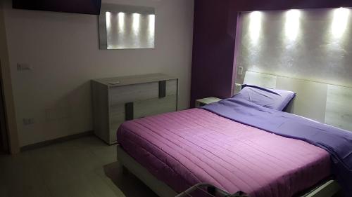 1 dormitorio con cama morada y mesa en CASA DAVID en Manfredonia