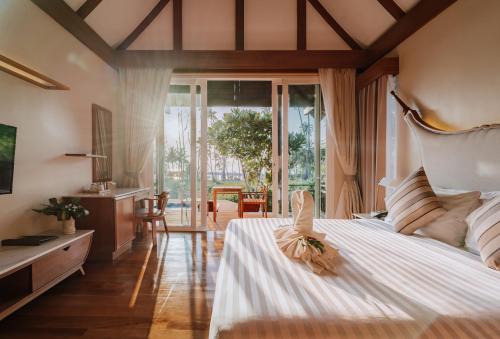 a bedroom with a large bed with a large window at Koh Kood Paradise Beach in Ko Kood