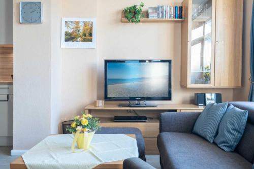 a living room with a couch and a tv at Villa Marin Wohnung 02 in Zinnowitz