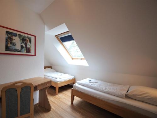 Habitación con 2 camas, mesa y ventana en Am Deich 39 en Zingst