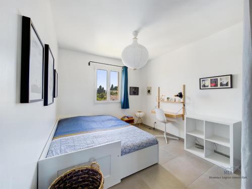 une chambre blanche avec un lit et un bureau dans l'établissement Villa Calisse, 6 personnes à Maillane, à Maillane