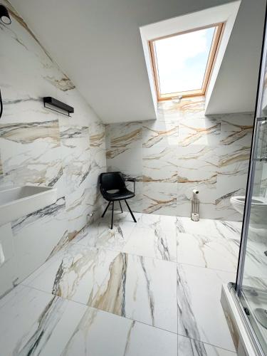 a bathroom with white marble flooring and a window at MILIA wine & event resort in Dunajský Klátov