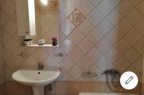 W łazience znajduje się umywalka i lustro. w obiekcie Loula's House w mieście Spetses