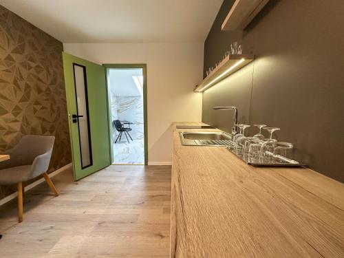 uma cozinha com um balcão com um lavatório e uma mesa em MILIA wine & event resort em Dunajský Klátov
