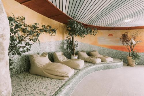 una fila de almohadas sentadas en una pared con plantas en Hotel Montana, en Obertauern